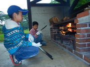 夕食づくり、火おこしは任せてと少年たち